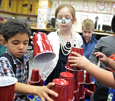 two students stacking cups