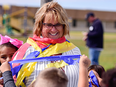 principal being wrapped in crepe paper with smile