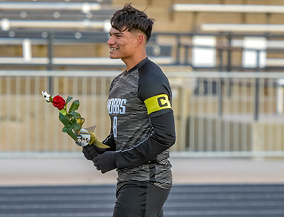 player holding flower and smiling