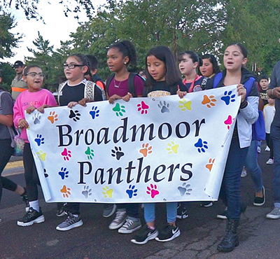 kids walking with broadmoor sign