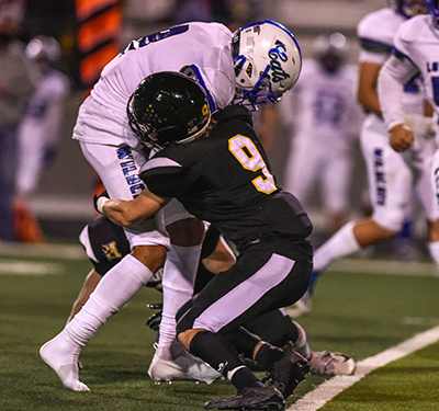 player in black uniform tackling player in white