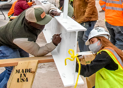 two people signing a construction  beam