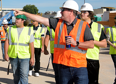group of people in hard hats with lead person pointing