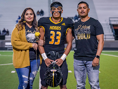 smiling parents with football player