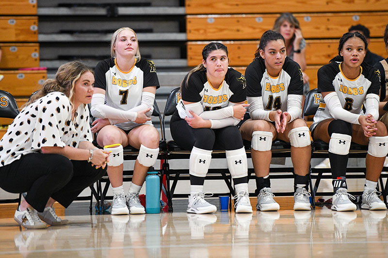 volleyball coach with players on bench