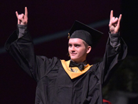 graduate with fingers pointing up